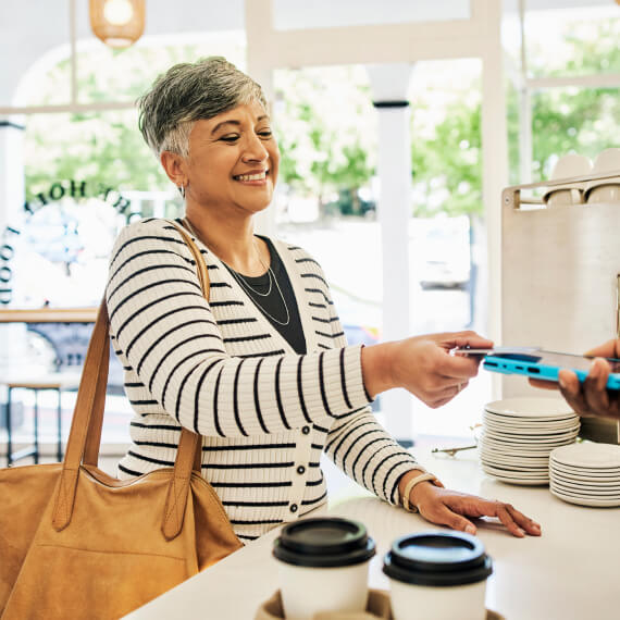 woman paying with a card at a cafe counter