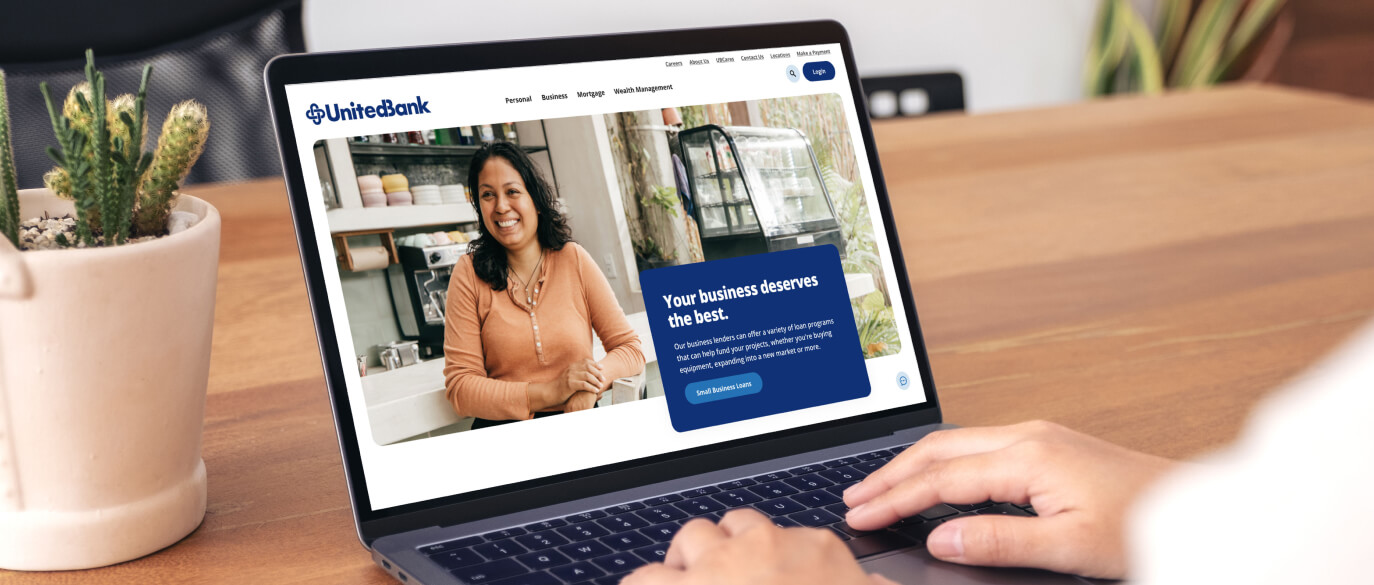 Person using laptop with United Bank website on screen