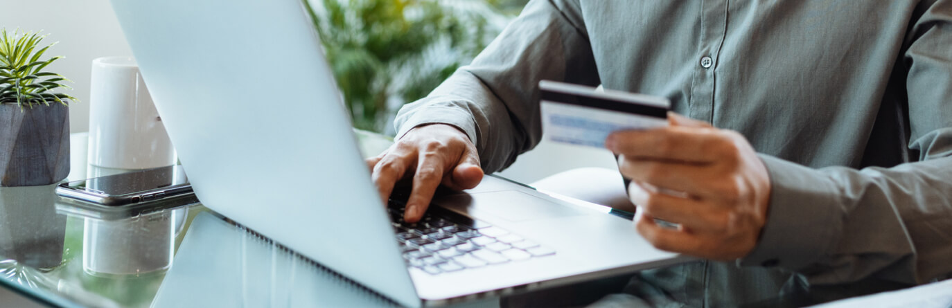 Man using laptop and credit/debit card