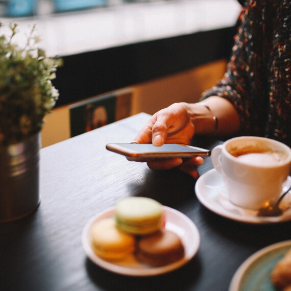 Close up of woman using mobile phone at a cafe