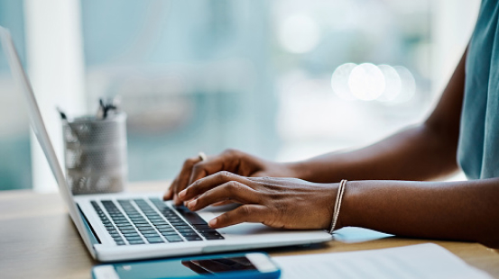 Woman typing on laptop keyboard