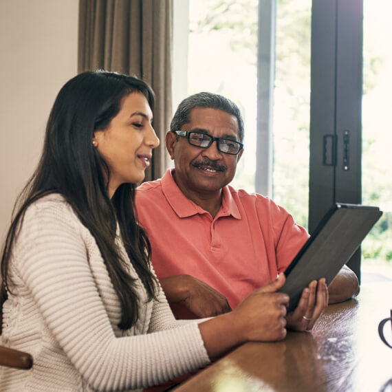 couple in kitchen looking at tablet device