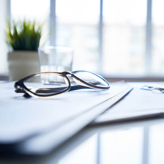 Glasses atop documents at a desk